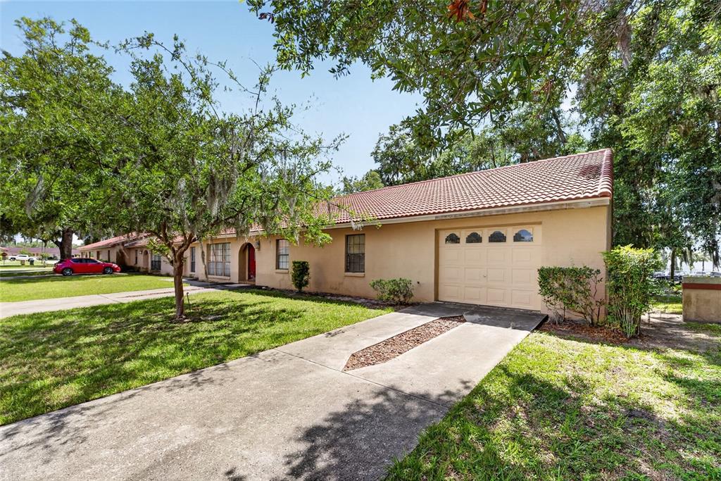 A single-story house with a tan stucco exterior, a tile roof, and an attached garage — 1826 SW 35TH AVENUE, OCALA, FL