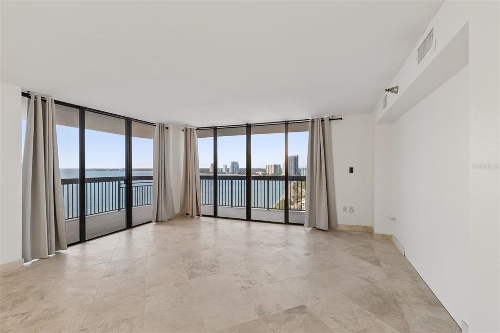 An empty living room with tile floors, floor-to-ceiling windows, and a view of the water — 2413 BAYSHORE BOULEVARD UNIT 1904, TAMPA, FL