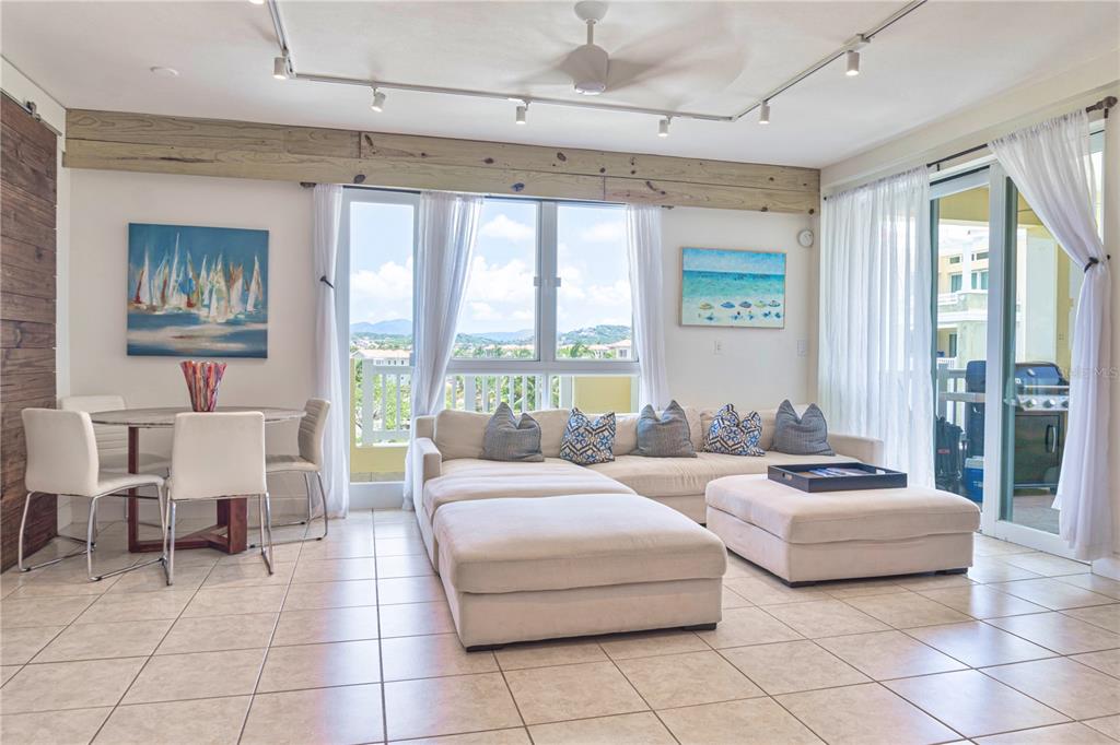 A living room features tile floors, a sectional sofa, a dining area, and large windows — 200 OCEAN DRIVE UNIT 245, HUMACAO, PR
