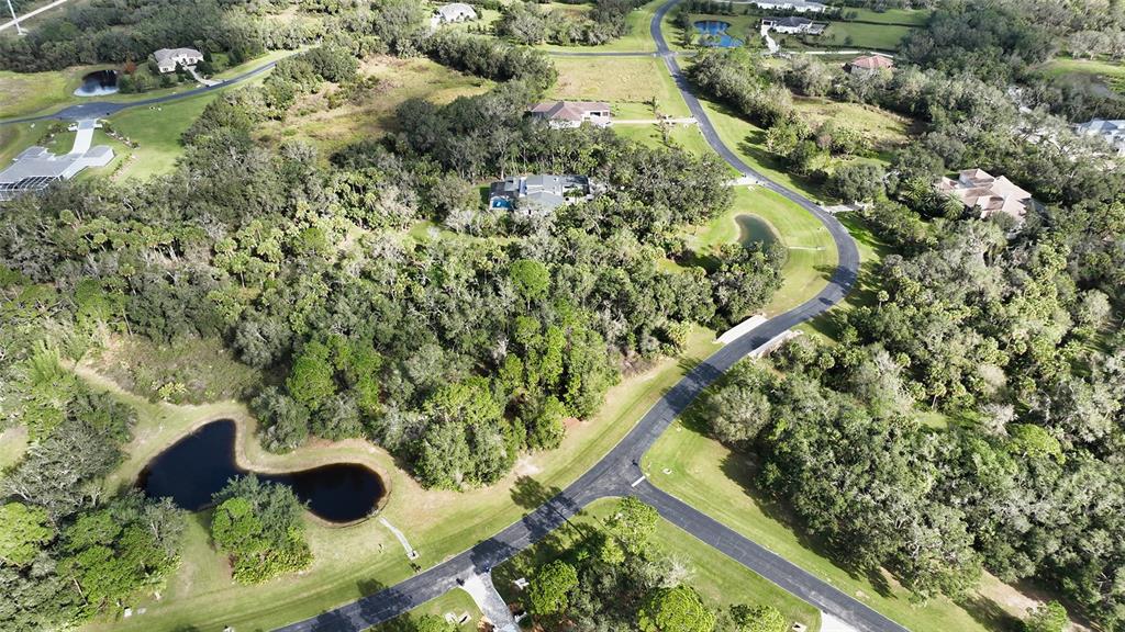 An aerial view shows a residential neighborhood with houses, winding roads, and several small ponds — 9255 SWAYING BRANCH ROAD, SARASOTA, FL