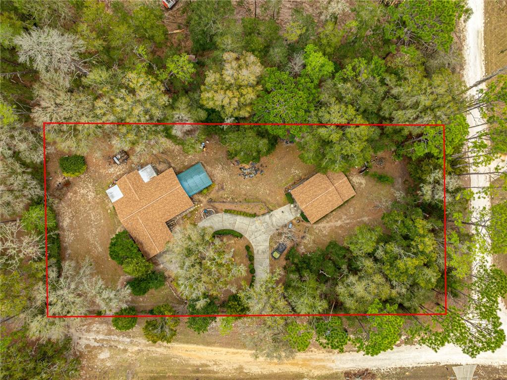An aerial view shows a house and detached garage on a wooded lot — 4551 SW 129TH COURT, OCALA, FL