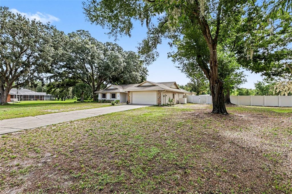 A swimming pool with a spa is enclosed by a screened lanai behind a house — 4504 DEER PARK PLACE, BRANDON, FL