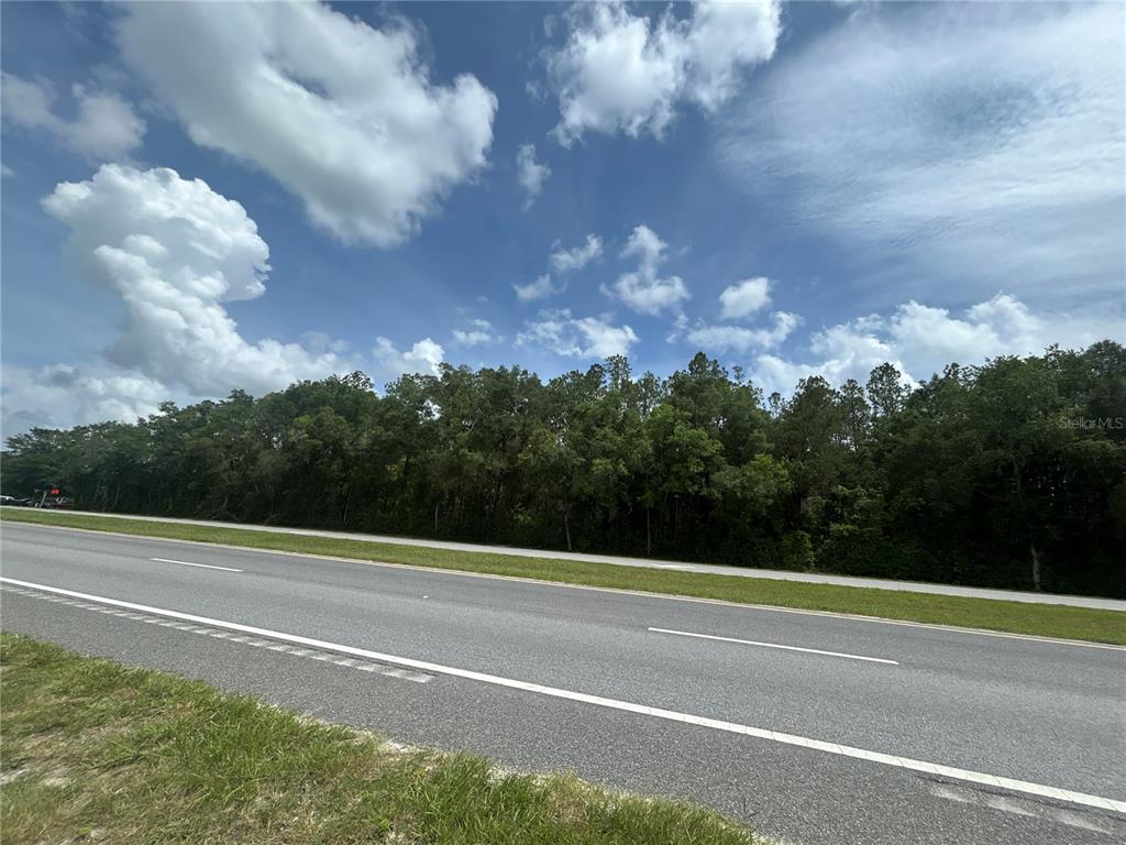 An aerial view shows a large wooded lot next to a highway and industrial building — 000 W NEWBERRY ROAD, NEWBERRY, FL