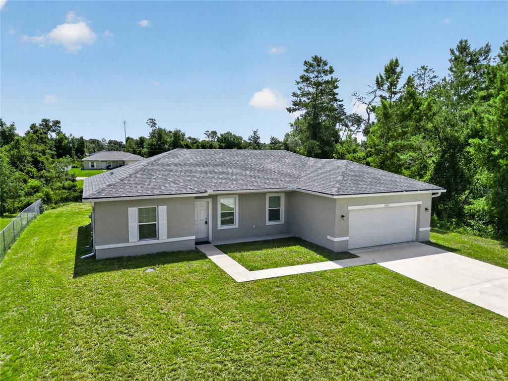 An aerial view of a single-story house with a gray exterior, shingled roof, and garage — 15475 SW 23RD AVENUE ROAD, OCALA, FL