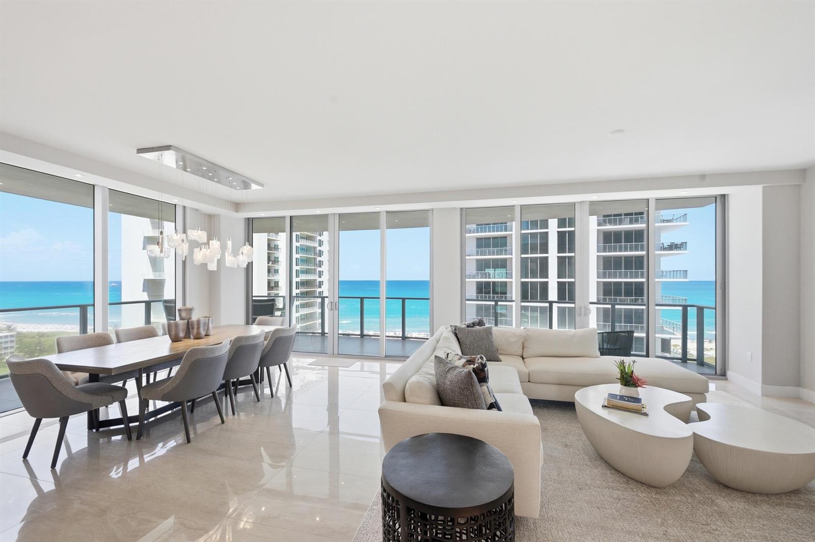 A modern living and dining area with floor-to-ceiling windows overlooking the ocean — 3100 N Ocean Drive # 1202, Singer Island FL 33404, SINGER ISLAND, FL