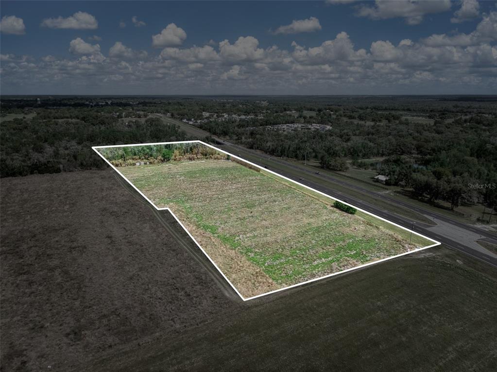An aerial view shows a vacant, rectangular plot of land outlined in white beside a road — 3515 US HIGHWAY 17 N, BOWLING GREEN, FL