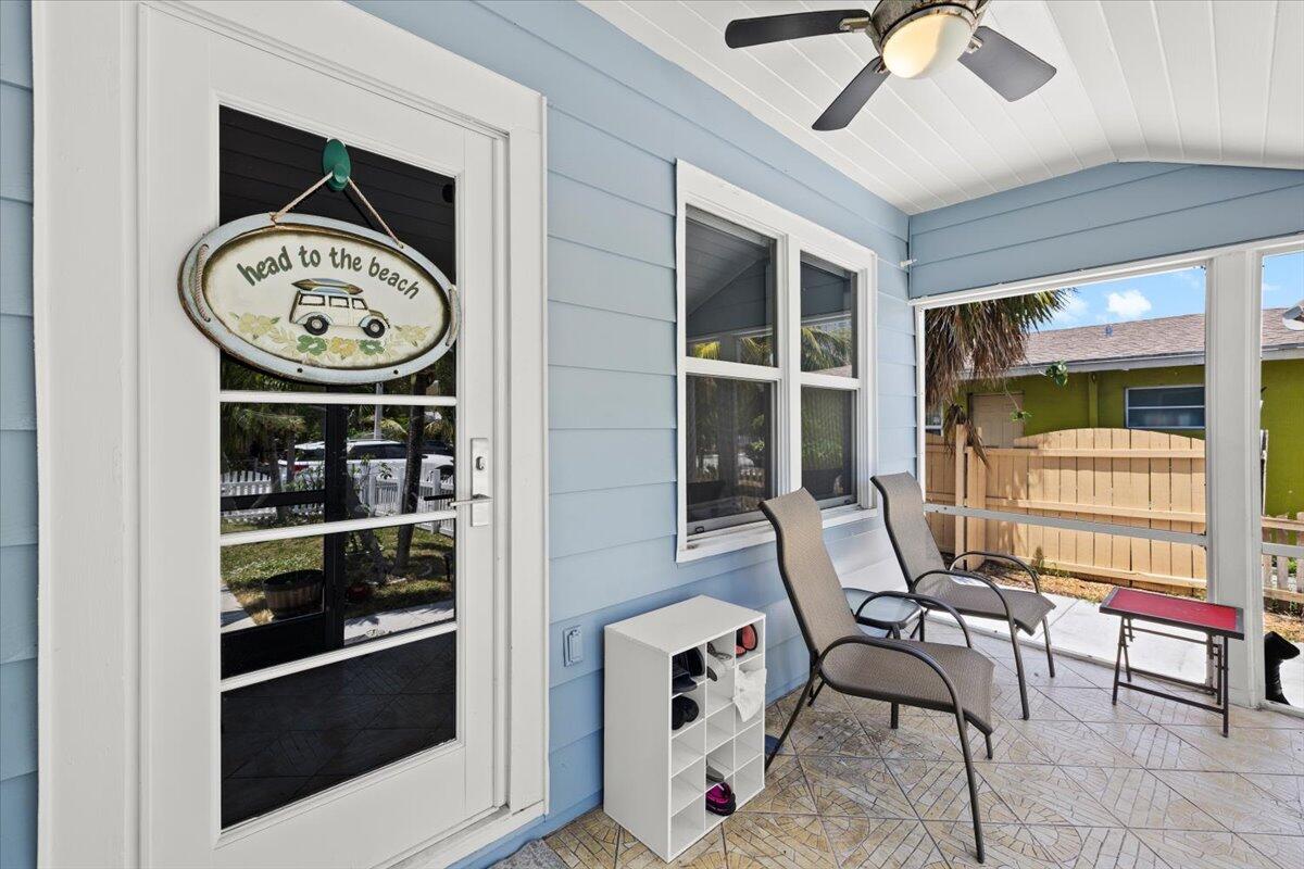 A light blue porch features a screen enclosure, two chairs, and a shoe rack — 915 N K Street, FL 33460, FL
