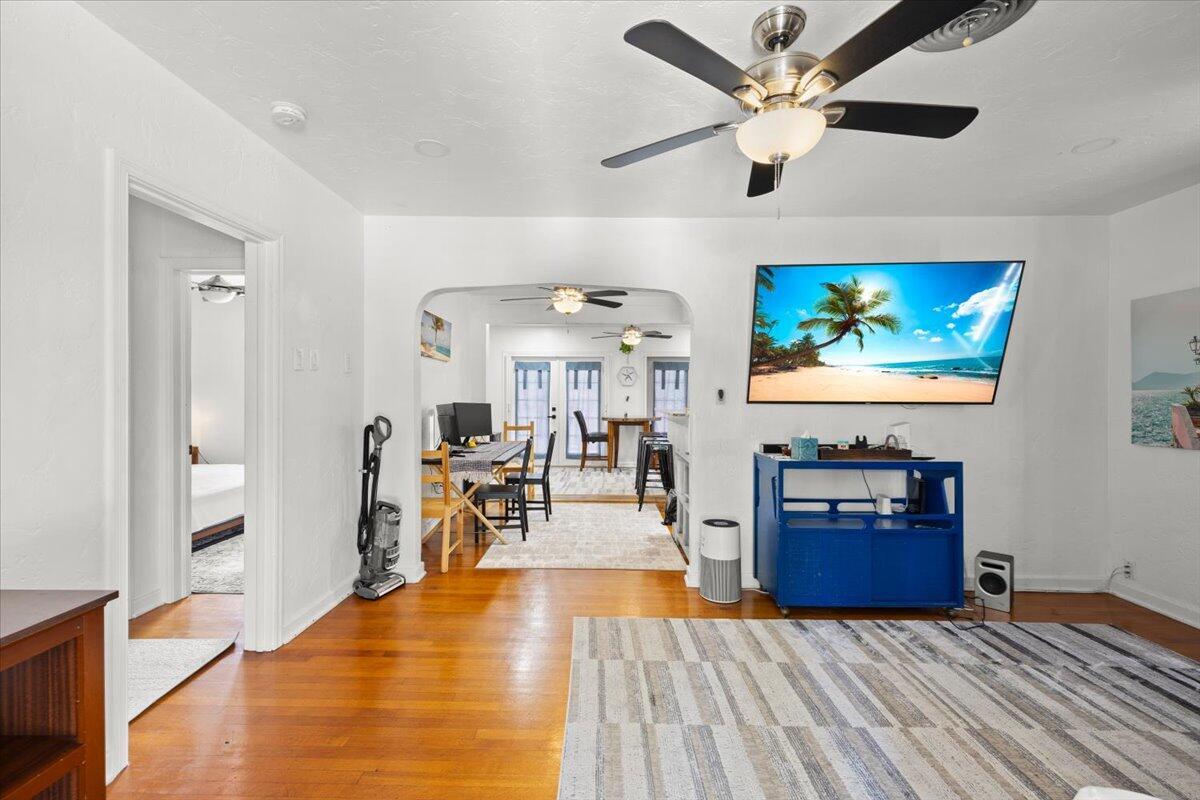 A living room with hardwood floors and a ceiling fan opens into a dining area — 915 N K Street, FL 33460, FL