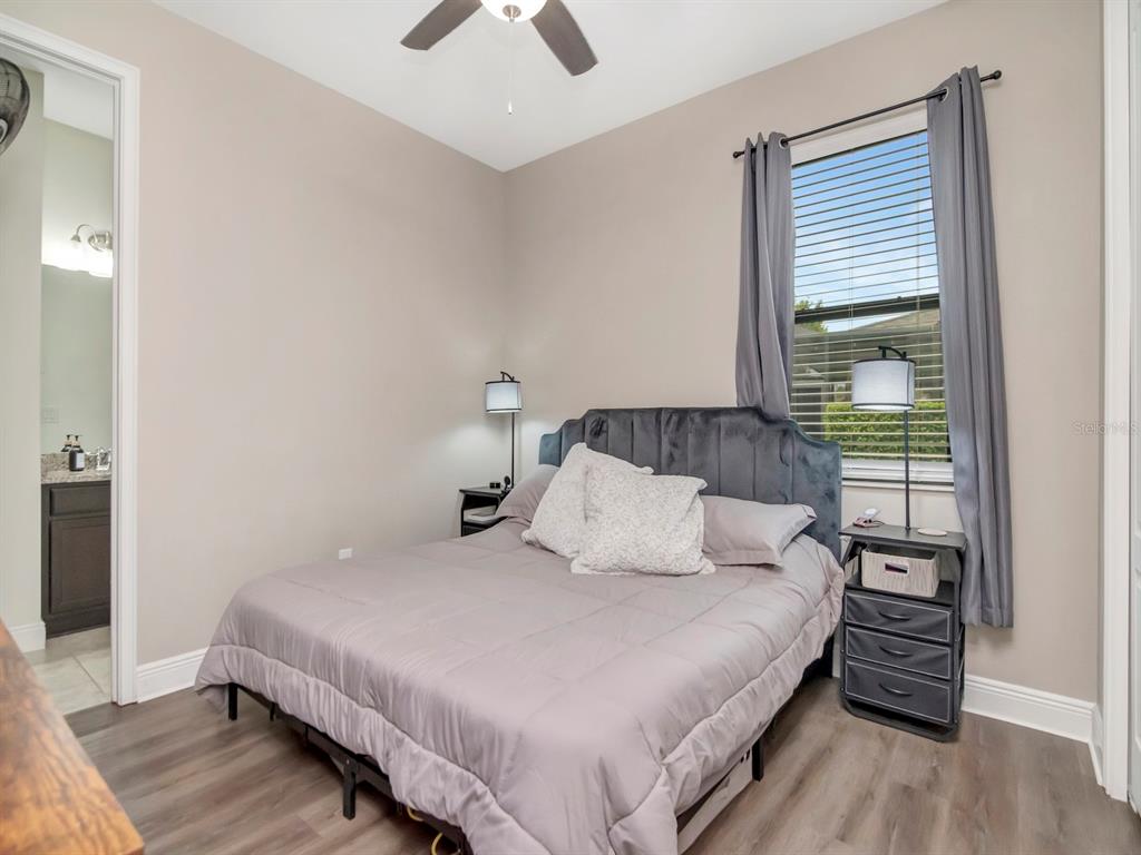 A bedroom features a gray upholstered headboard, a bed with gray bedding, and a window — 8213 SUMMER BROOK COURT, LAND O LAKES, FL