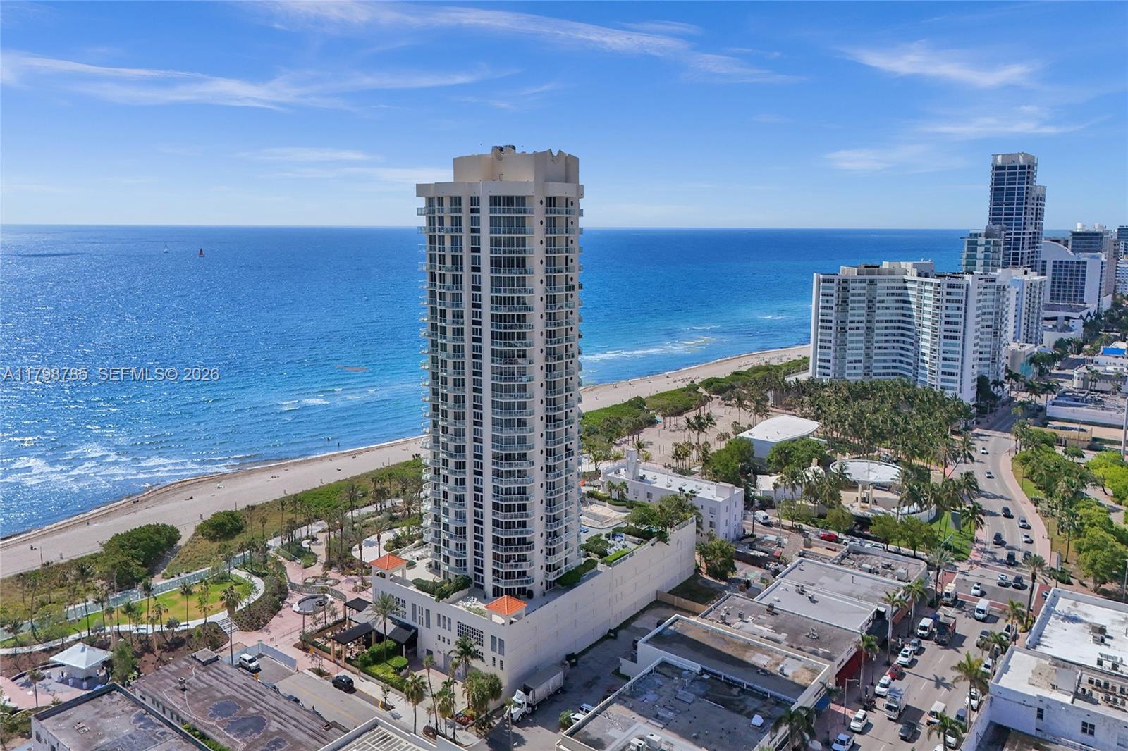 An aerial view shows a tall residential tower situated along a sandy beach and ocean — 7330 Ocean Ter # C, Miami Beach FL 33141, MIAMI BEACH, FL
