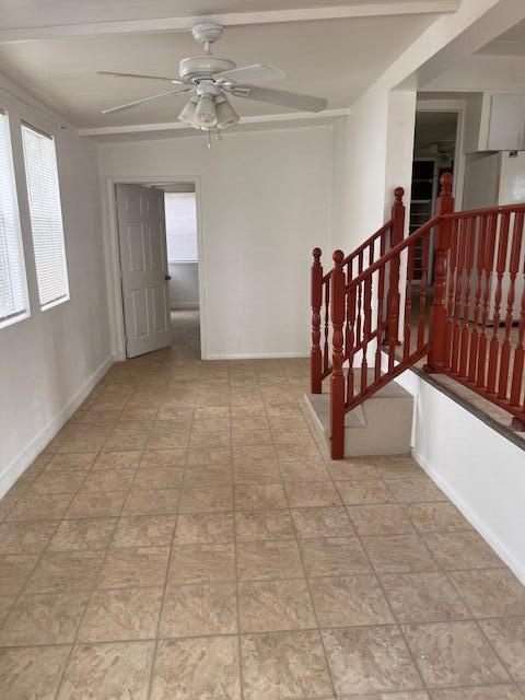 A room with tiled flooring, a ceiling fan, a doorway, and a wooden staircase railing — 4149 88th Court S, Boynton Beach FL 33436, BOYNTON BEACH, FL