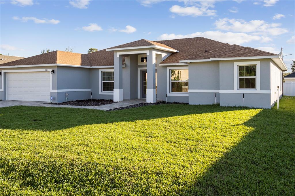 A single-story house with a gray exterior, a two-car garage, and a brown shingled roof — 1160 NELSON MEADOW LANE, KISSIMMEE, FL