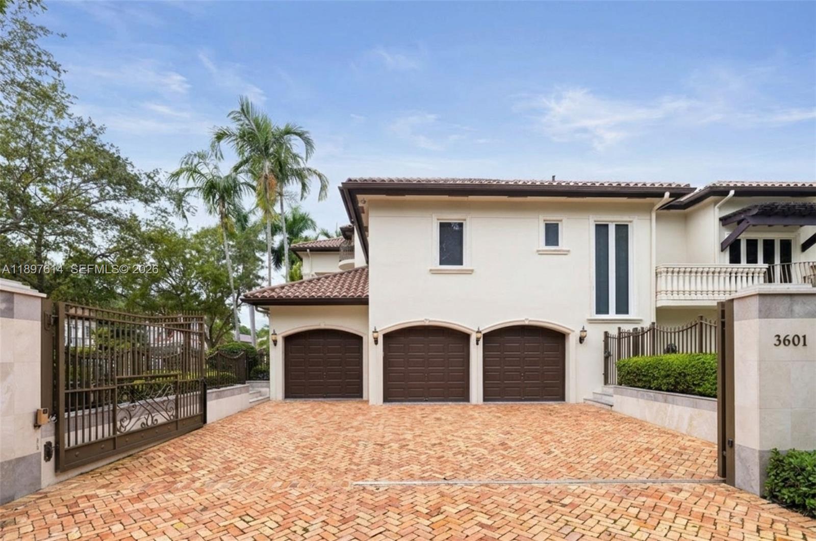 A three-car garage with arched doors faces a brick driveway in front of a house — 3601 Matheson Ave, Miami FL 33133, MIAMI, FL