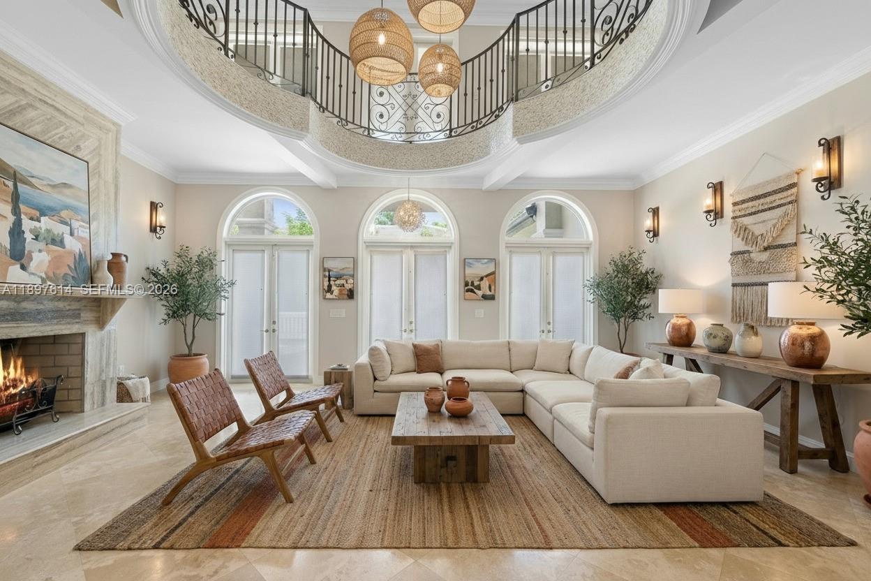 A spacious living room features a large sectional sofa, a fireplace, and a curved balcony — 3601 Matheson Ave, Miami FL 33133, MIAMI, FL