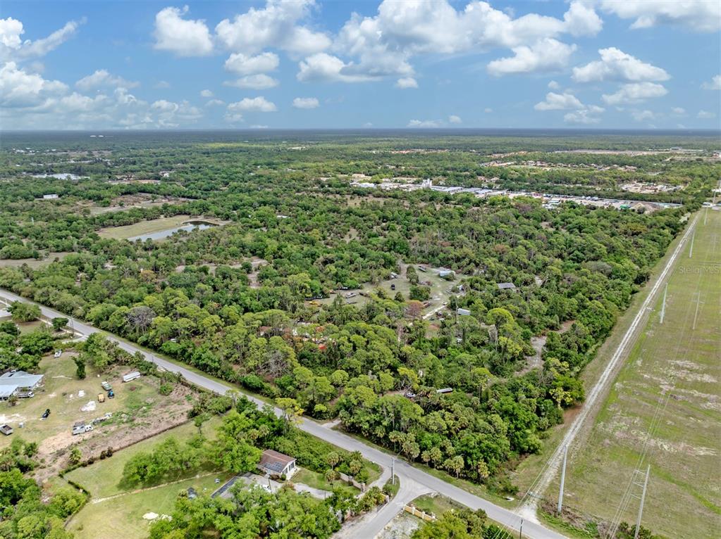 An aerial view shows a wooded lot bordered by a road and power lines — 400 S HAVANA ROAD, VENICE, FL