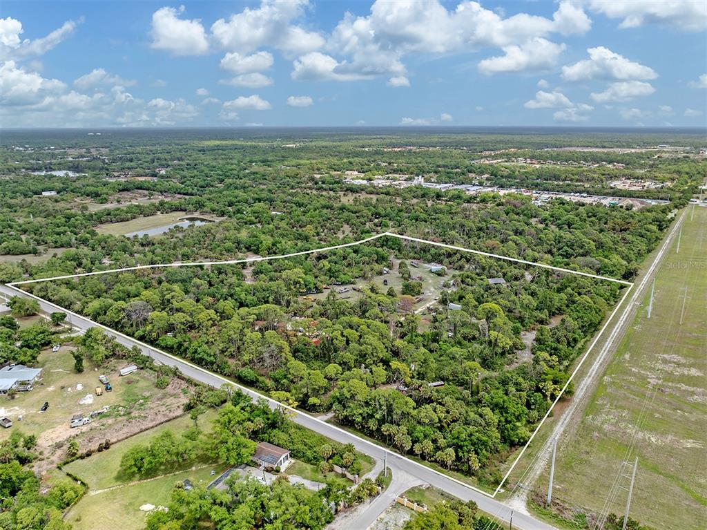 An aerial view shows a large, wooded rectangular lot bordered by roads and power lines — 400 S HAVANA ROAD, VENICE, FL