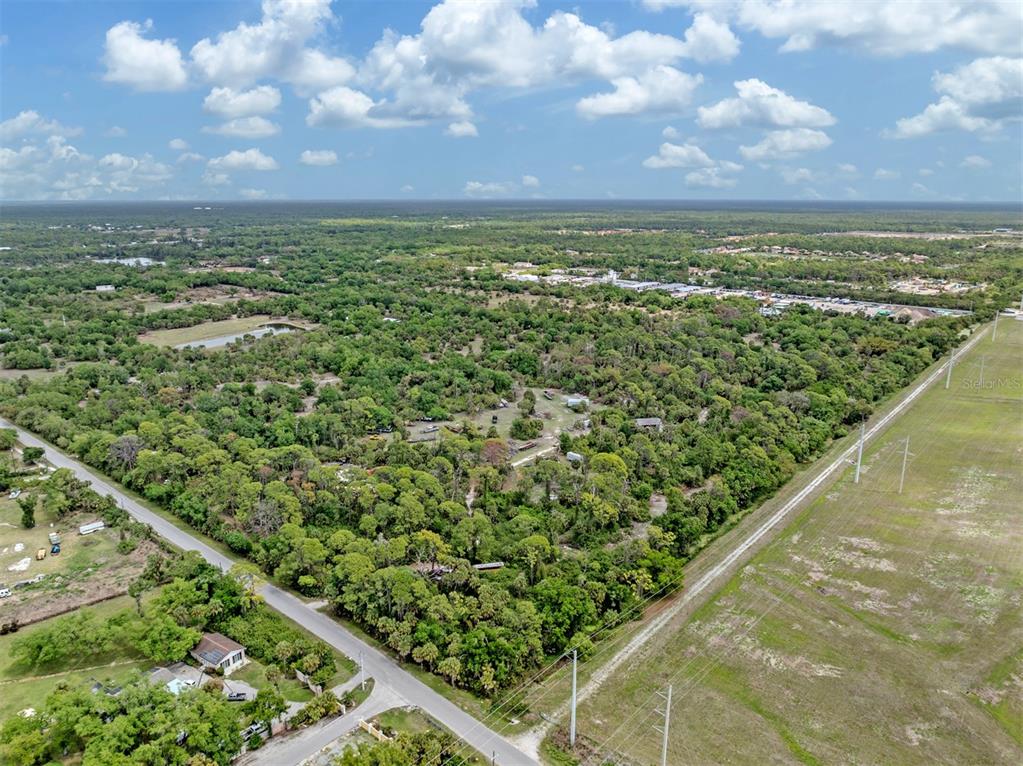 An aerial view shows a wooded lot bordered by a road and a power line easement — 400 S HAVANA ROAD, VENICE, FL