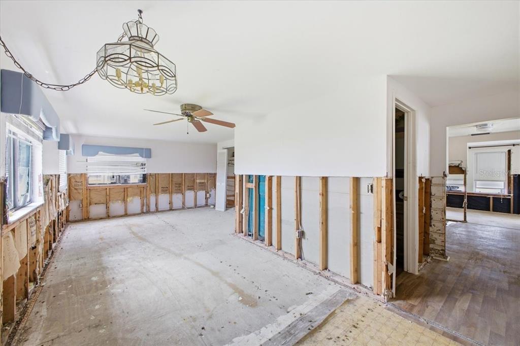 An unfinished room with exposed wall studs, removed drywall, and a ceiling fan — 4436 106TH STREET W, BRADENTON, FL