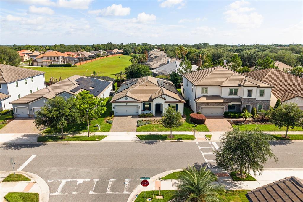 An aerial view of a suburban street featuring several single-family homes with tiled roofs — 7916 WANDERING WAY, ORLANDO, FL