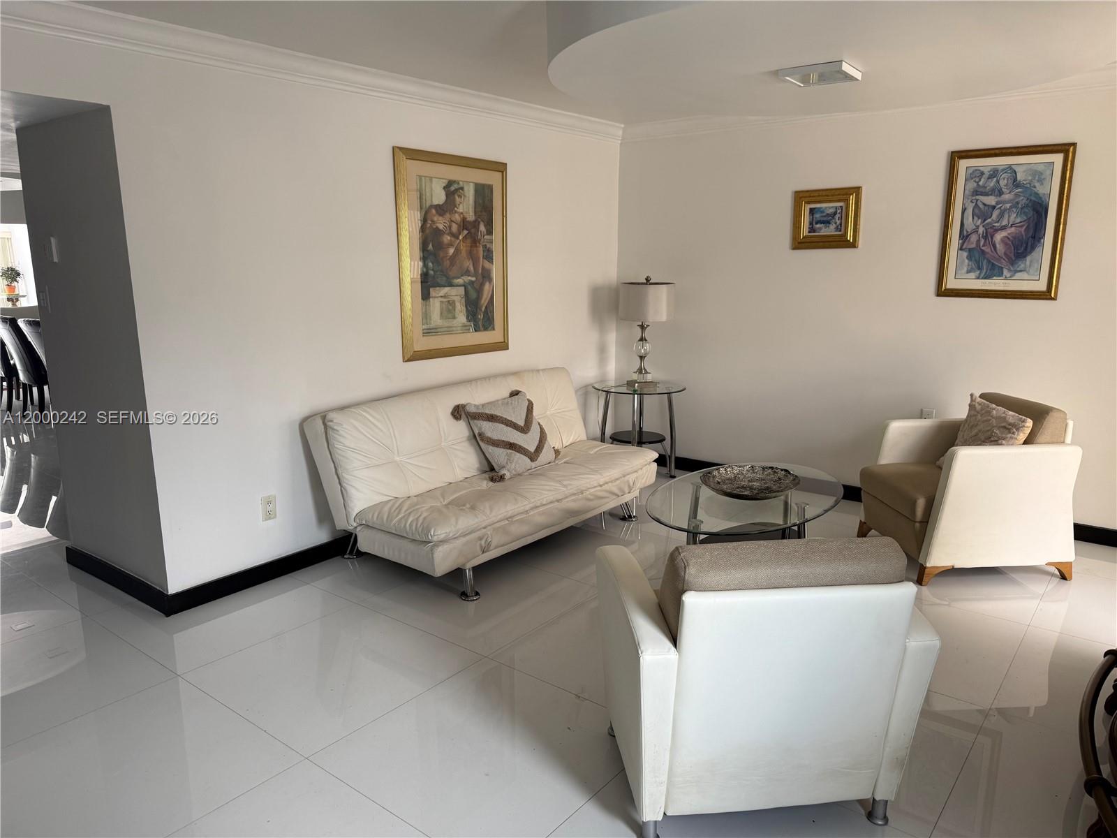 A living room features white tile floors, a white sofa, two armchairs, and framed wall art — 13505 NE 23rd Ct, North Miami FL 33181, NORTH MIAMI, FL