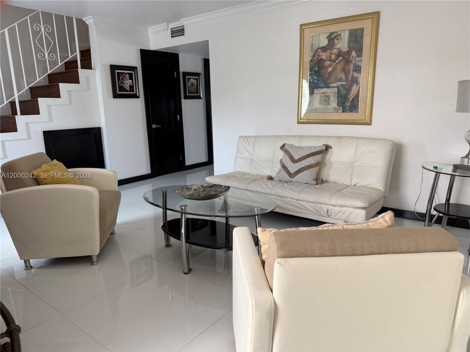 A living room features white tile floors, a staircase, a sofa, and two armchairs — 13505 NE 23rd Ct, North Miami FL 33181, NORTH MIAMI, FL