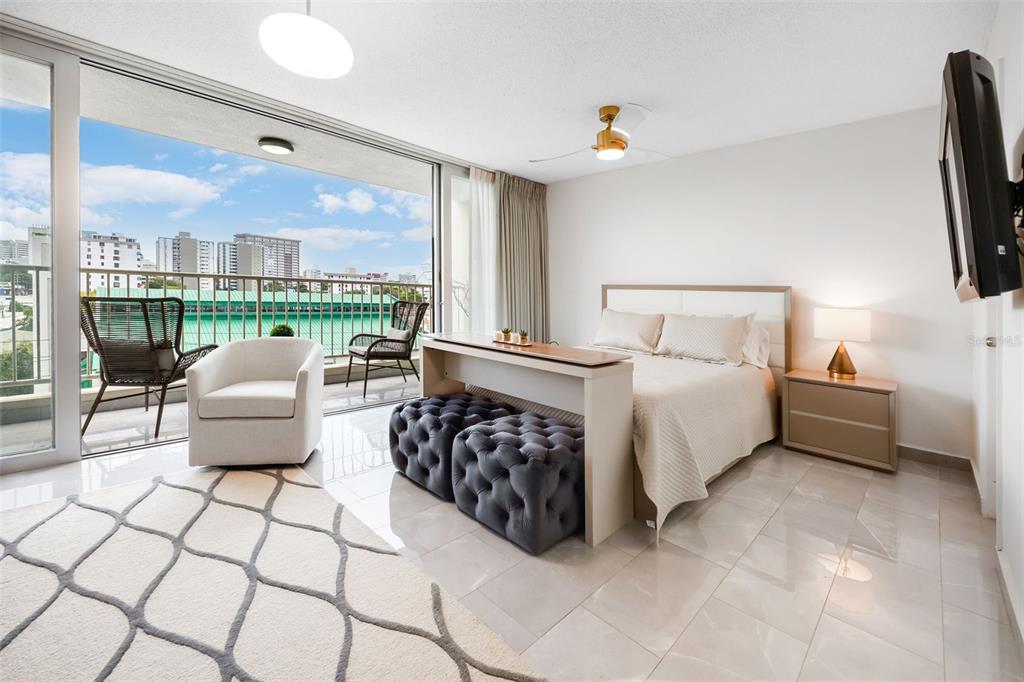 A bedroom with a bed, a balcony, and a city view through sliding glass doors — 1477 ASHFORD UNIT 608, SAN JUAN, PR