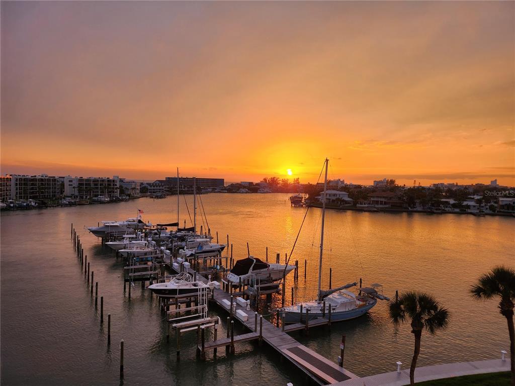 An aerial view of a marina with several boats docked at sunset — 9525 BLIND PASS ROAD UNIT 505, ST PETE BEACH, FL