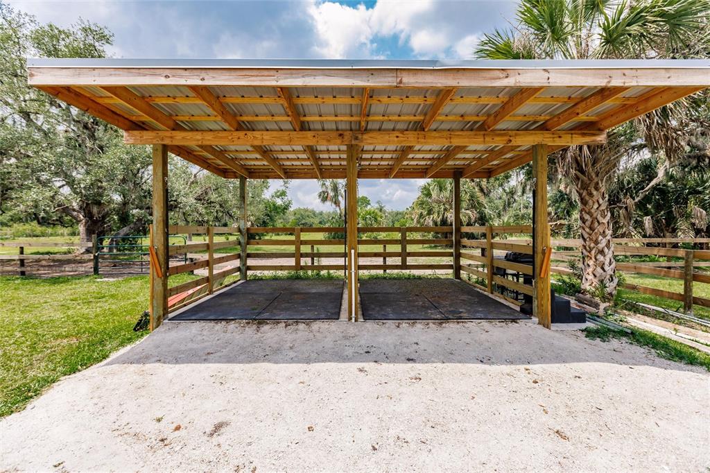 A two-stall open-air horse shelter with a metal roof and rubber flooring in a pasture — 9325 SW LIPE ROAD, ARCADIA, FL
