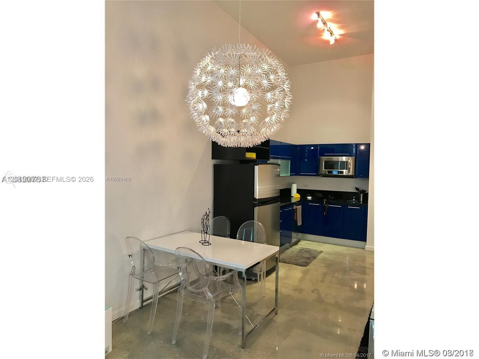 A kitchen and dining area features blue cabinets, a white table, and a dandelion-style pendant light — 253 NE 2nd St # 312, Miami FL 33132, MIAMI, FL