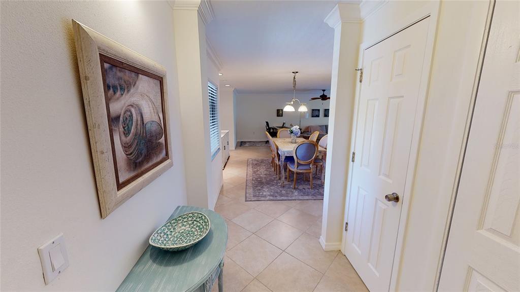 A tiled entryway leads to a dining room with a table and chairs — 2749 ORCHID OAKS DRIVE UNIT 302, SARASOTA, FL
