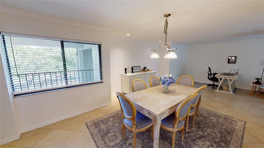 A dining area with a wooden table, chairs, and a desk in the background — 2749 ORCHID OAKS DRIVE UNIT 302, SARASOTA, FL