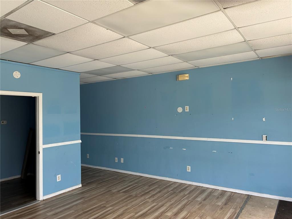An interior room with blue walls, white chair rail molding, and a drop ceiling — 2911 39TH STREET UNIT 200, ORLANDO, FL