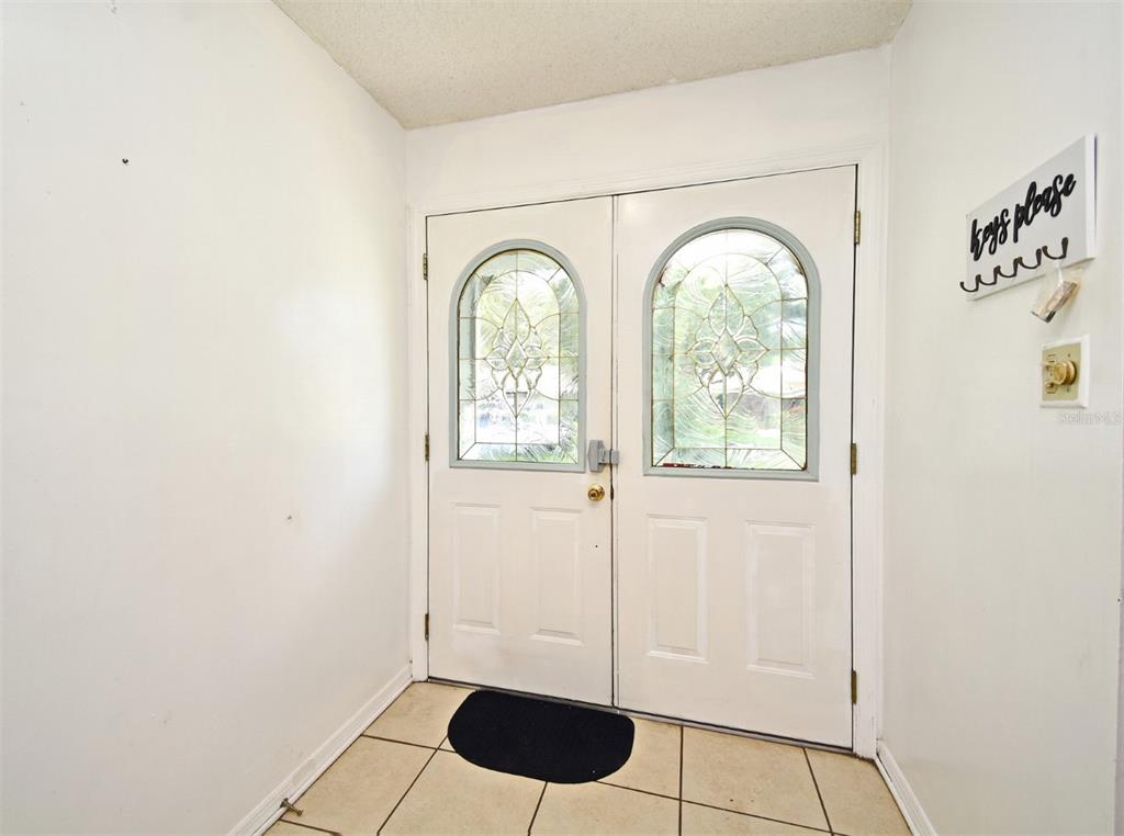 An entryway features white double doors with arched glass panels and light-colored tile flooring — 5133 BRENDA DRIVE, ORLANDO, FL