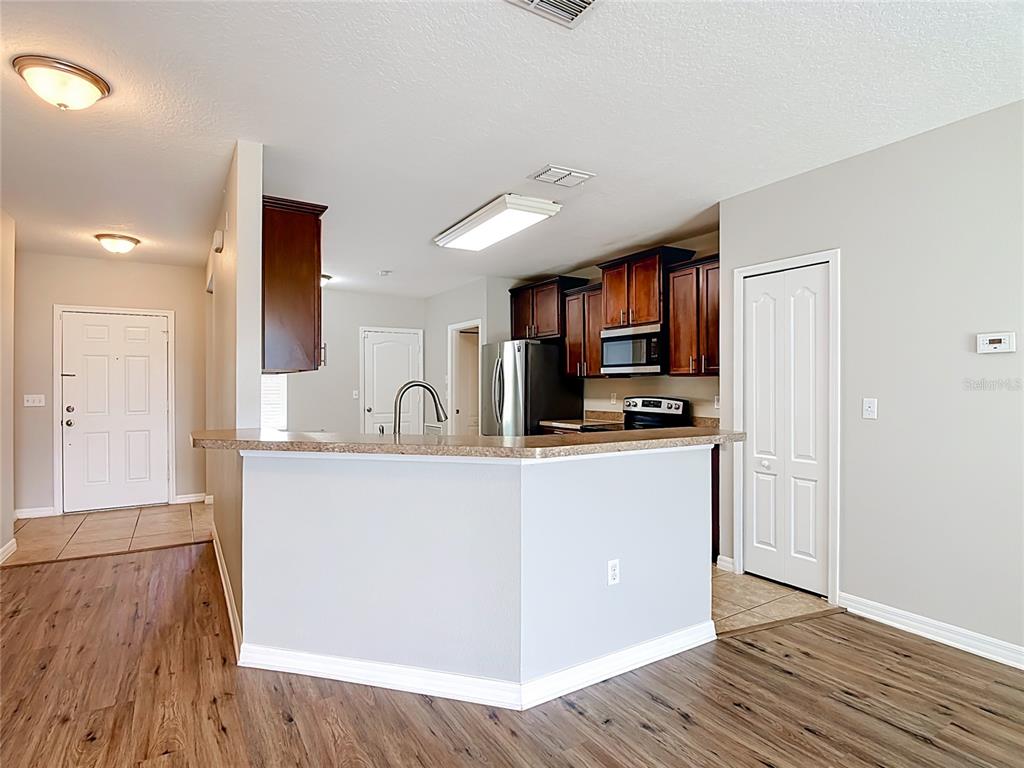 A kitchen with dark wood cabinets, stainless steel appliances, and a breakfast bar — 1562 TAMARIND ROAD, DAVENPORT, FL