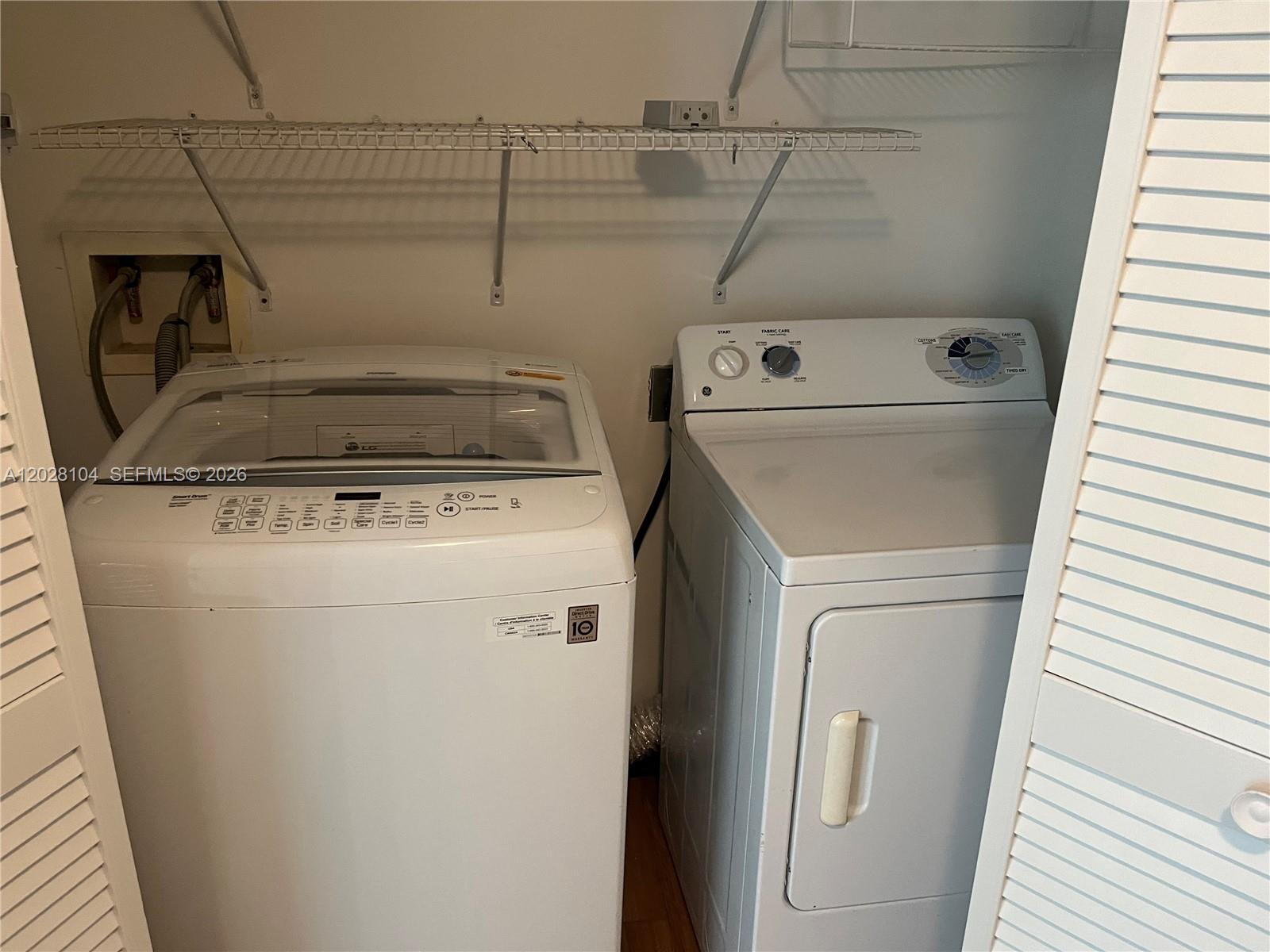 A laundry closet contains a white top-loading washing machine and a matching clothes dryer — 1800 N Bayshore Dr # 915, Miami FL 33132, MIAMI, FL