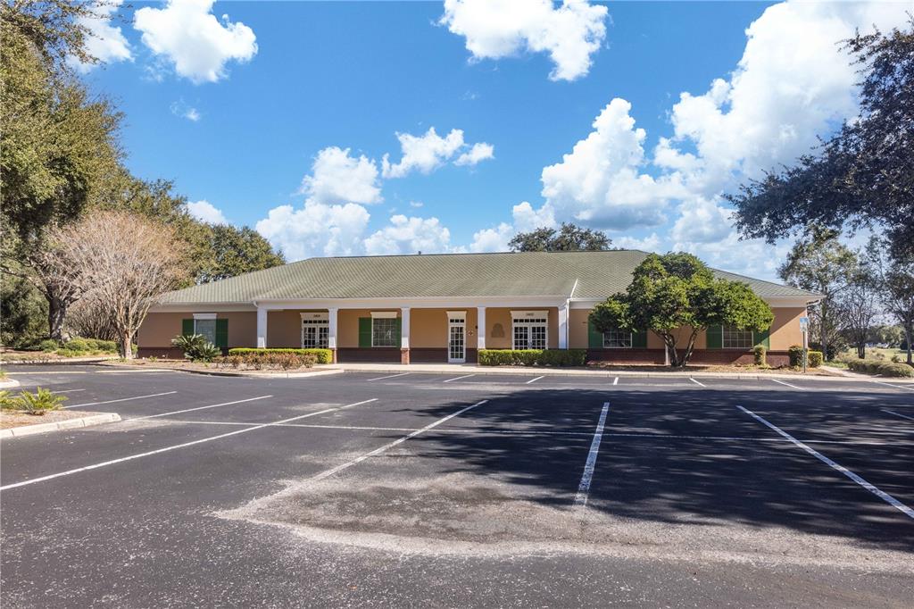 A single-story commercial building with a tan exterior and a parking lot in front — 3400 SOUTHERN TRACE, THE VILLAGES, FL