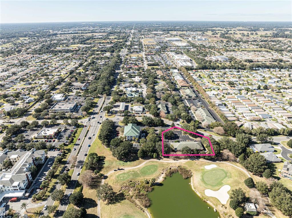 An aerial view shows a commercial building highlighted in pink next to a golf course — 3400 SOUTHERN TRACE, THE VILLAGES, FL