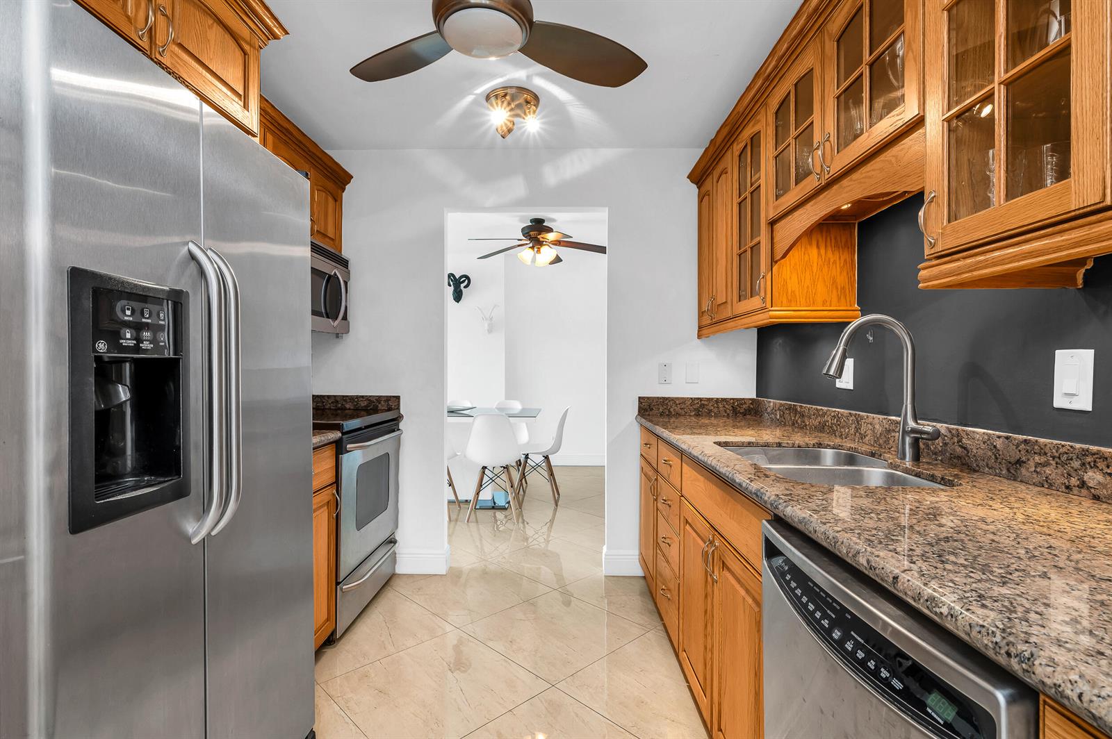 A kitchen with wood cabinets, granite countertops, stainless steel appliances, and tile flooring — 1111 S Ocean Boulevard # 420, Boca Raton FL 33432, BOCA RATON, FL