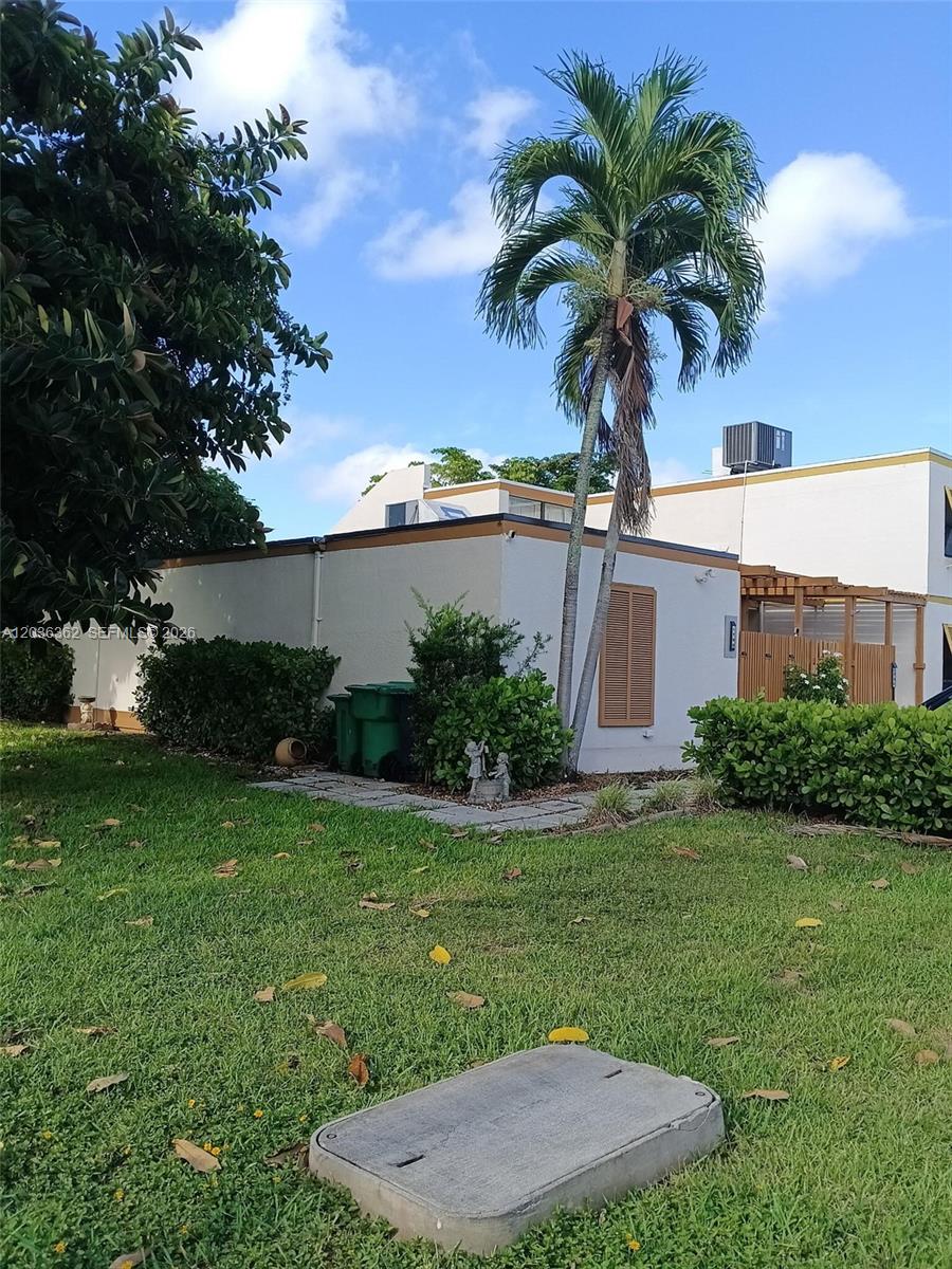 A single-story building with a palm tree, green bushes, and a concrete utility cover — 1700 SW 131st Place Cir S, Miami FL 33175, MIAMI, FL
