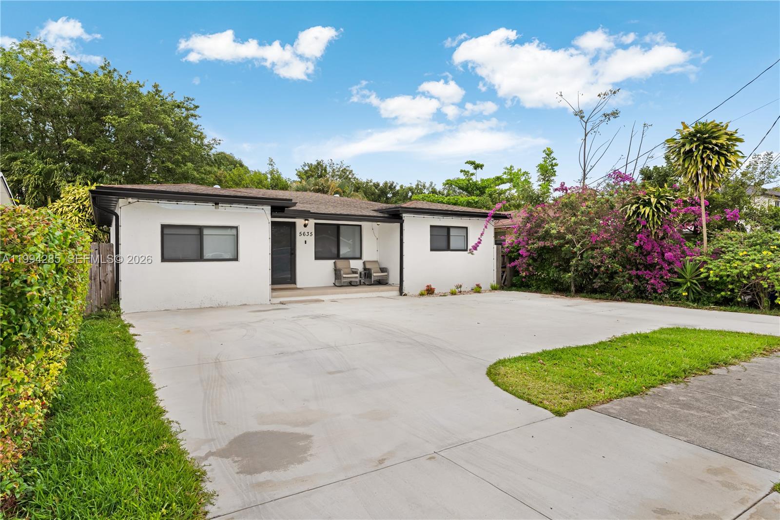 A single-story white house with a large concrete driveway and a small front porch — 5635 Pierce St, Hollywood FL 33021, HOLLYWOOD, FL
