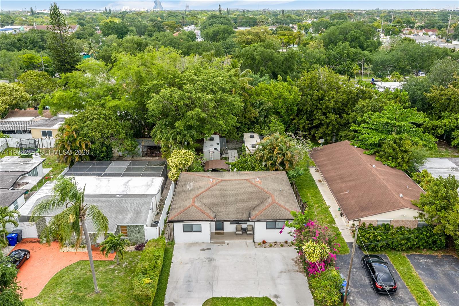An aerial view shows a single-story house with a concrete driveway and surrounding trees — 5635 Pierce St, Hollywood FL 33021, HOLLYWOOD, FL