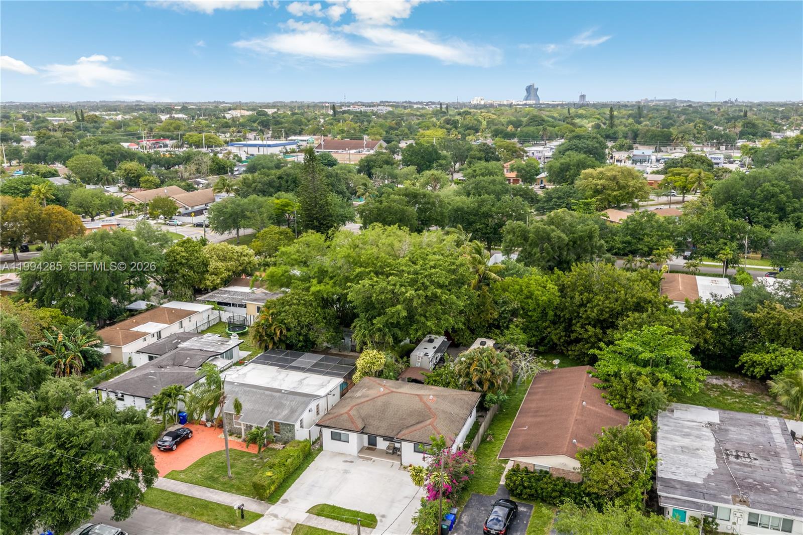 An aerial view shows several single-story residential houses surrounded by lush green trees and lawns — 5635 Pierce St, Hollywood FL 33021, HOLLYWOOD, FL