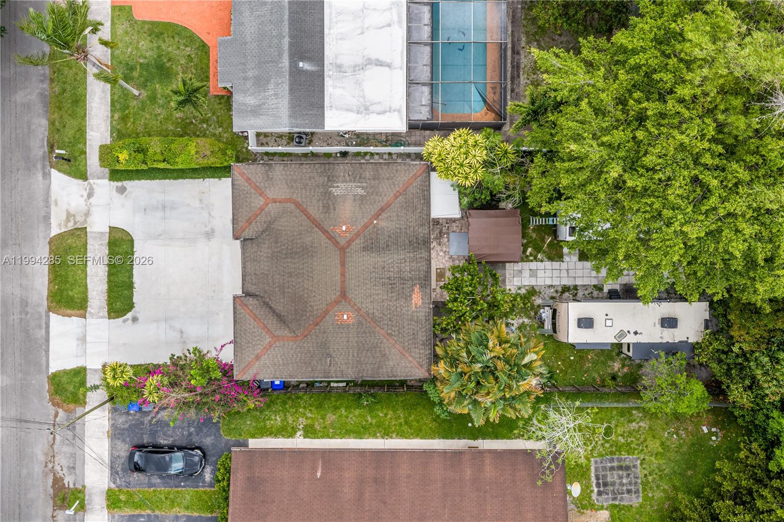 An aerial view shows a house with a brown roof, a driveway, and a backyard — 5635 Pierce St, Hollywood FL 33021, HOLLYWOOD, FL