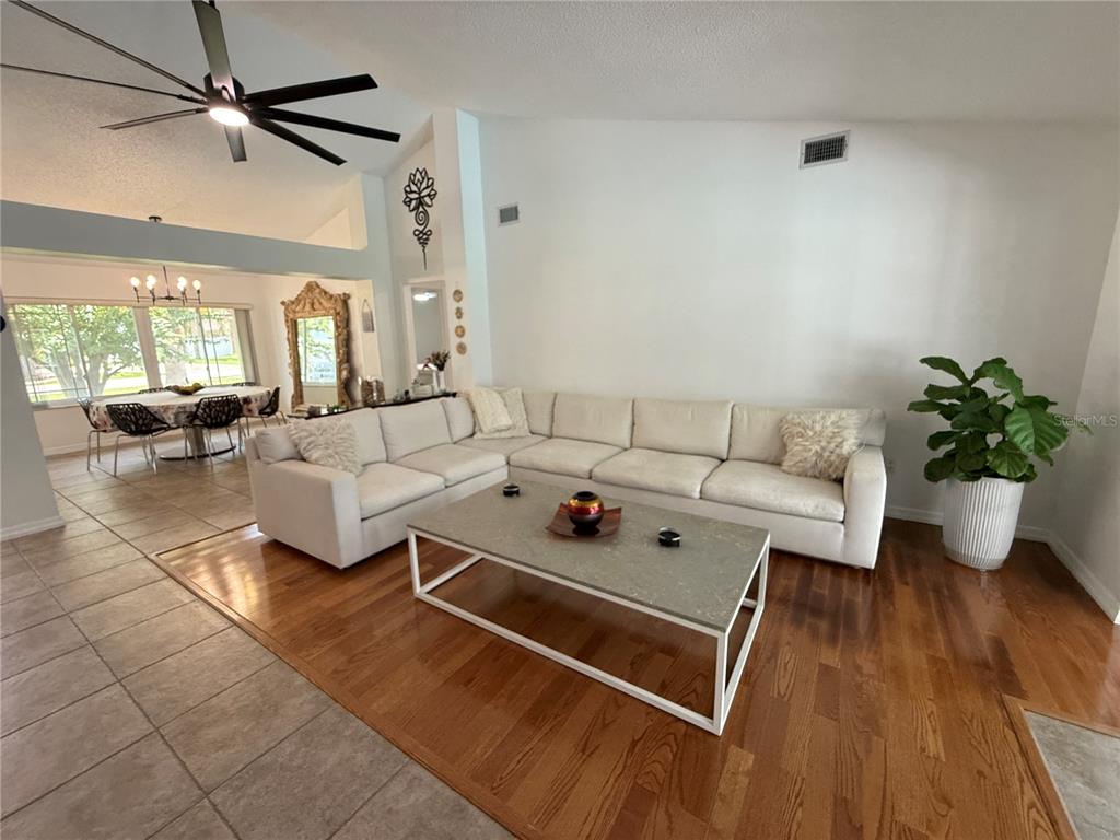 A living room with a white sectional sofa, coffee table, and hardwood floors — 77 CIMMARON DRIVE, PALM COAST, FL