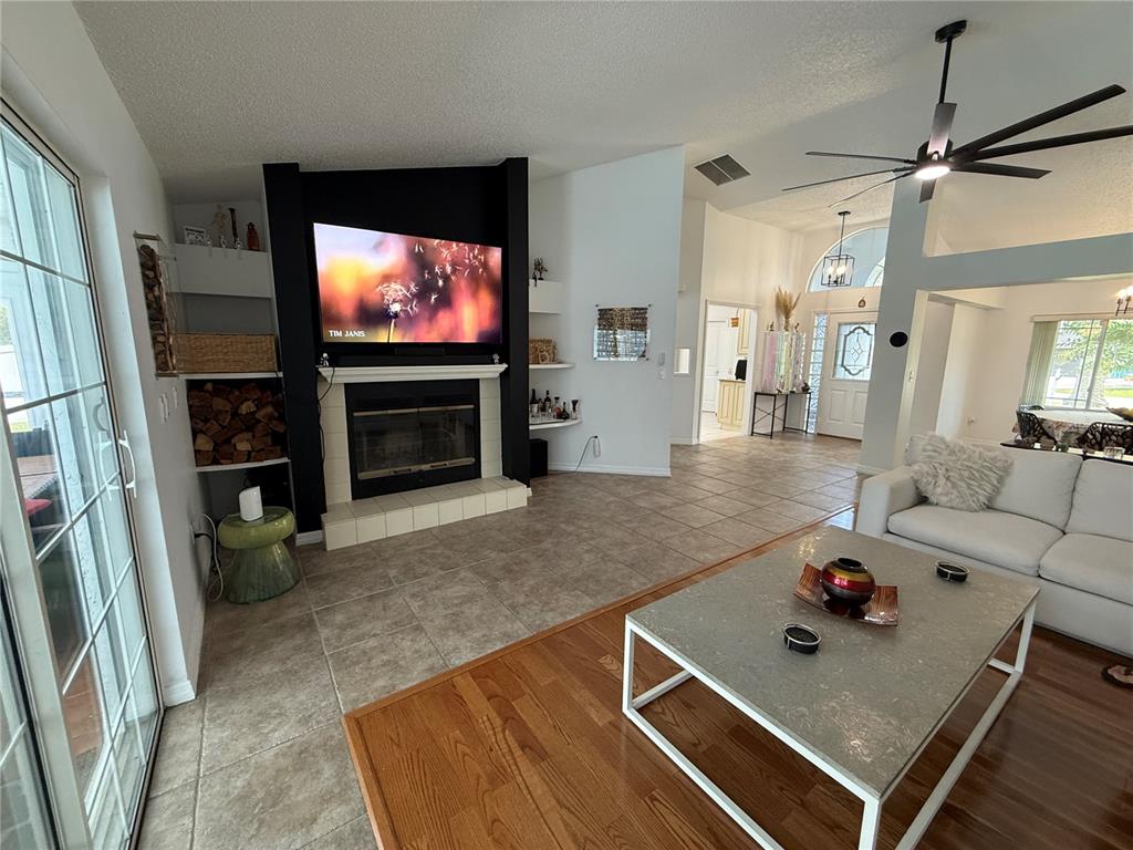 A living room features a black fireplace wall, tile flooring, and a white sofa — 77 CIMMARON DRIVE, PALM COAST, FL