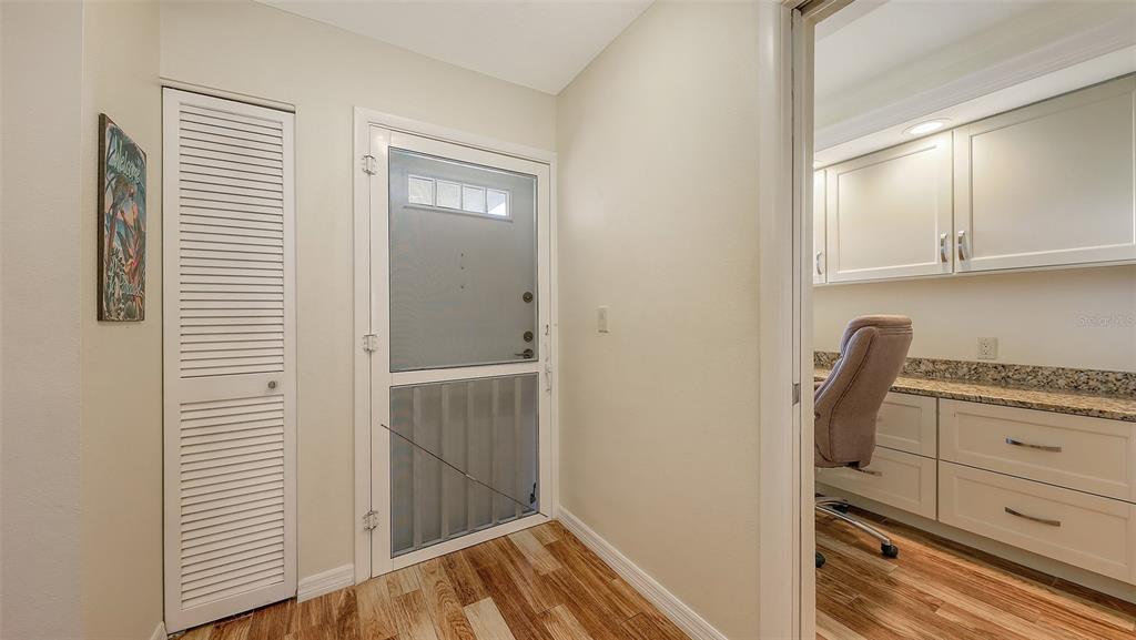 A view of an entryway with a louvered closet door, a storm door, and an office — 8779 MIDNIGHT PASS ROAD UNIT 401H, SARASOTA, FL
