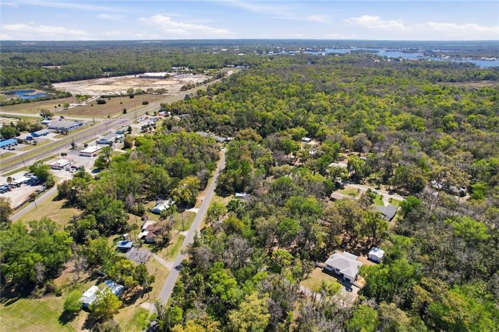 An aerial view shows a residential area with scattered houses surrounded by dense trees and roads — 1541 NW 21ST STREET, CRYSTAL RIVER, FL