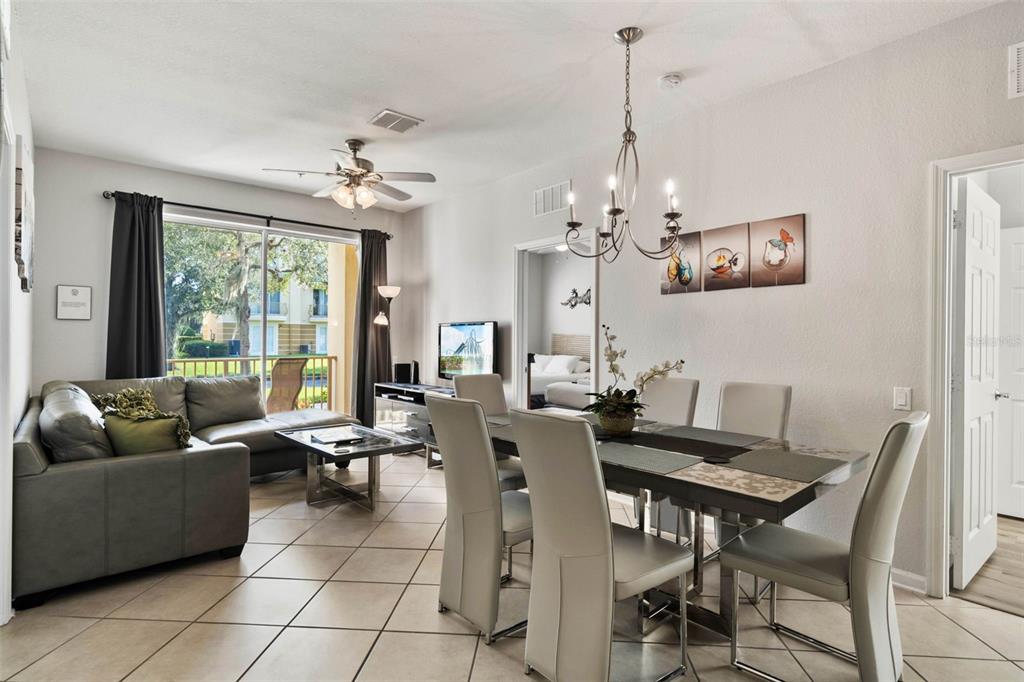 A living and dining area with tile floors, a sectional sofa, and a glass-topped table — 4802 CAYVIEW AVENUE UNIT 10814, ORLANDO, FL