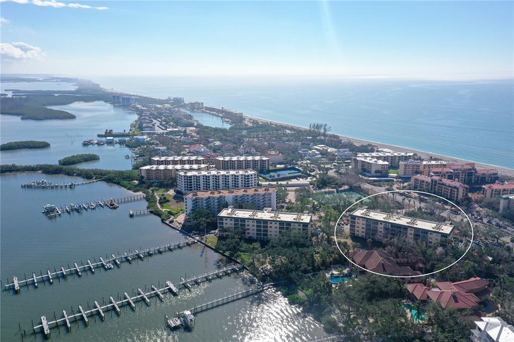 An aerial view shows a coastal residential area with a circled multi-story apartment building — 8625 MIDNIGHT PASS ROAD UNIT 305B, SARASOTA, FL