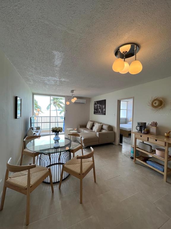 An open-concept living and dining area features tile floors, a glass table, and balcony views — Tower 1 ISLETA MARINA UNIT 4C, FAJARDO, PR